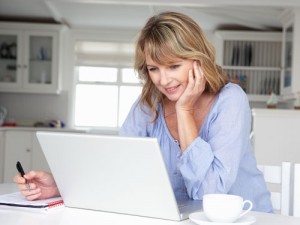 Mid age woman working at home on laptop